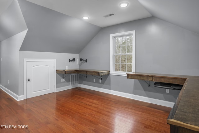 bonus room featuring baseboards, lofted ceiling, wood finished floors, and visible vents