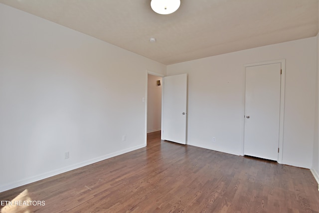 unfurnished bedroom featuring dark wood-style floors and baseboards