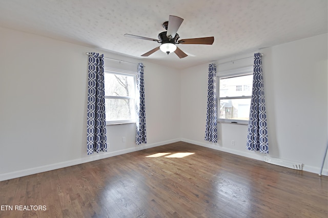 spare room with visible vents, baseboards, a healthy amount of sunlight, and wood finished floors