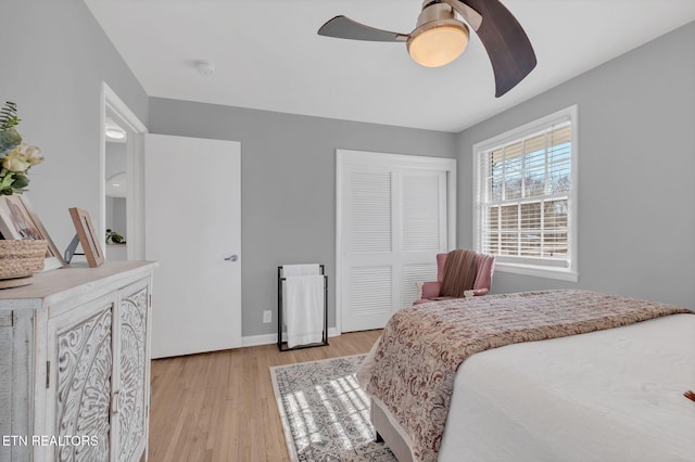 bedroom with light hardwood / wood-style floors, a closet, and ceiling fan