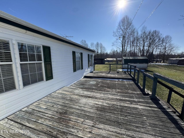 wooden terrace featuring a storage unit and a yard