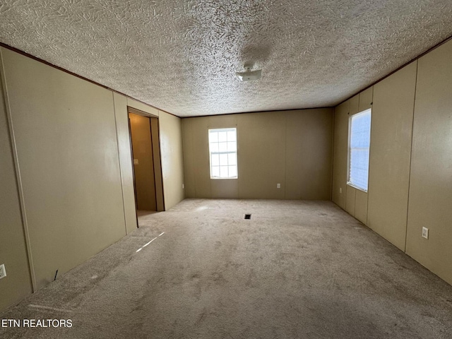 unfurnished bedroom featuring a textured ceiling and light carpet