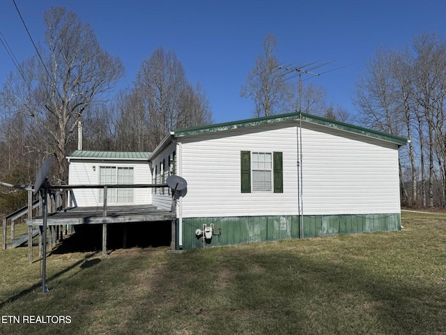 view of side of home featuring a wooden deck and a yard