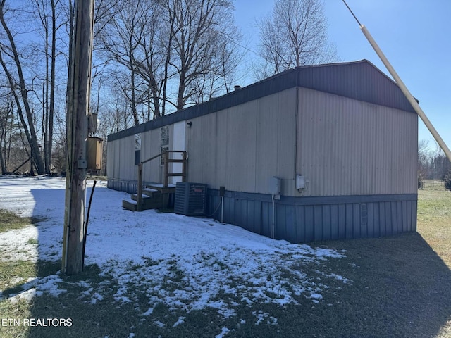 view of snow covered exterior featuring central AC