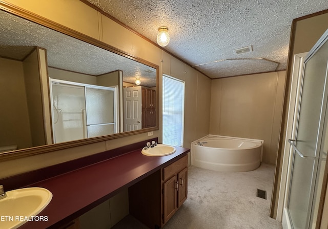 bathroom with vanity, shower with separate bathtub, and a textured ceiling