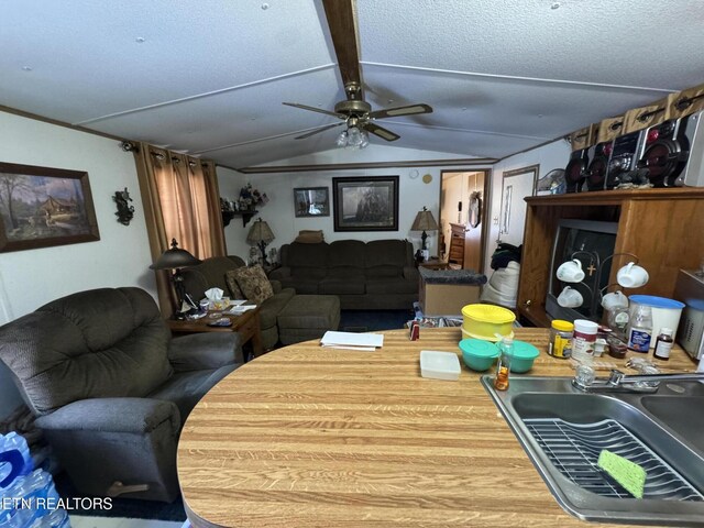 living room featuring sink, ceiling fan, a textured ceiling, and lofted ceiling