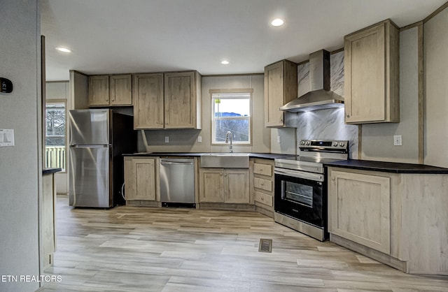 kitchen featuring wall chimney exhaust hood, light brown cabinetry, sink, stainless steel appliances, and light hardwood / wood-style floors