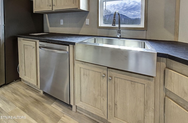 kitchen featuring sink, stainless steel dishwasher, light hardwood / wood-style floors, and light brown cabinets