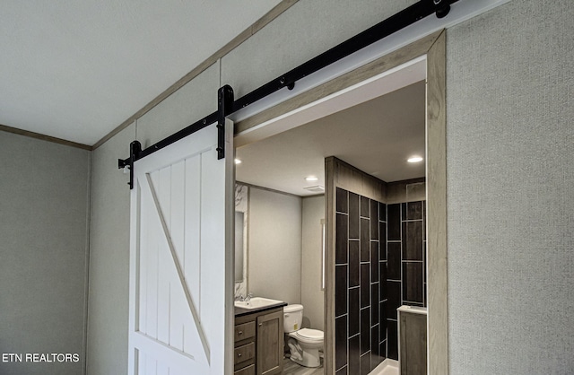 bathroom with ornamental molding, vanity, toilet, and a shower