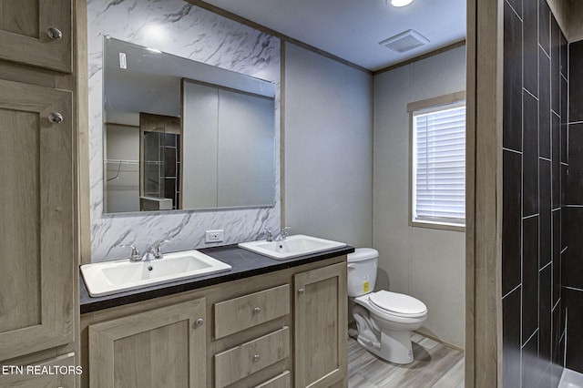 bathroom with wood-type flooring, vanity, and toilet