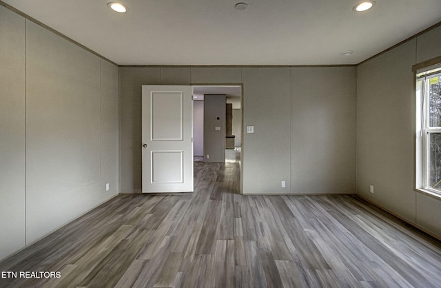 empty room with ornamental molding and light hardwood / wood-style floors