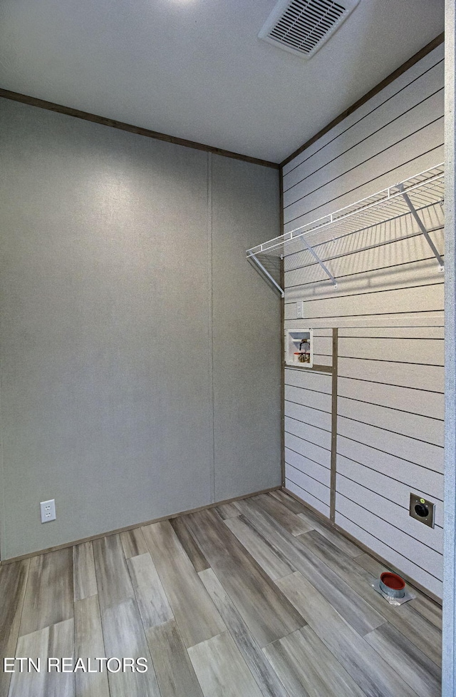 interior space with hookup for an electric dryer and light hardwood / wood-style floors