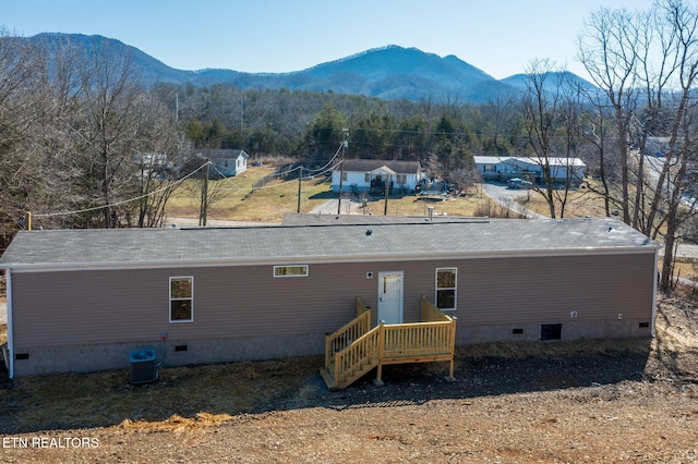 back of property with central AC unit and a mountain view