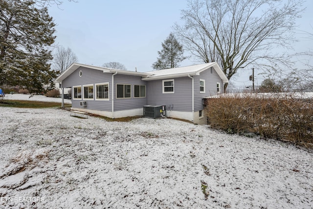 snow covered property featuring central AC