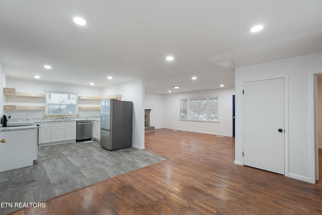 kitchen featuring white cabinets, stainless steel appliances, and hardwood / wood-style floors