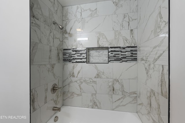 bathroom featuring tiled shower / bath