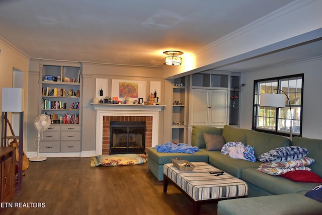 living room with built in features, dark hardwood / wood-style flooring, ornamental molding, and a fireplace