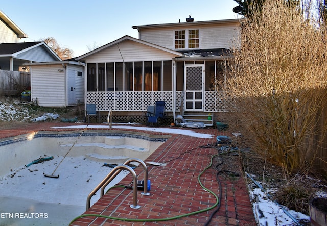 rear view of property featuring a patio area and a sunroom