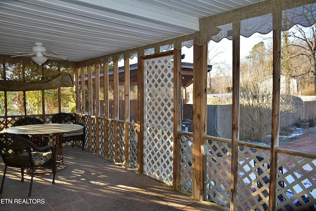 unfurnished sunroom with ceiling fan