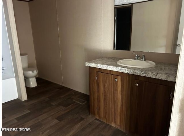 bathroom with toilet, wood-type flooring, and vanity