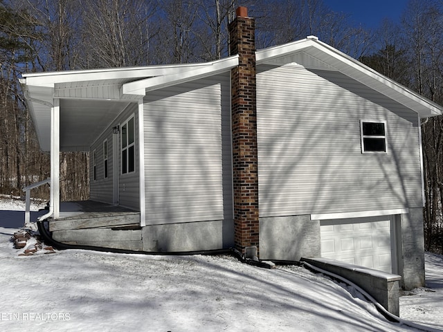 view of snow covered exterior with a garage