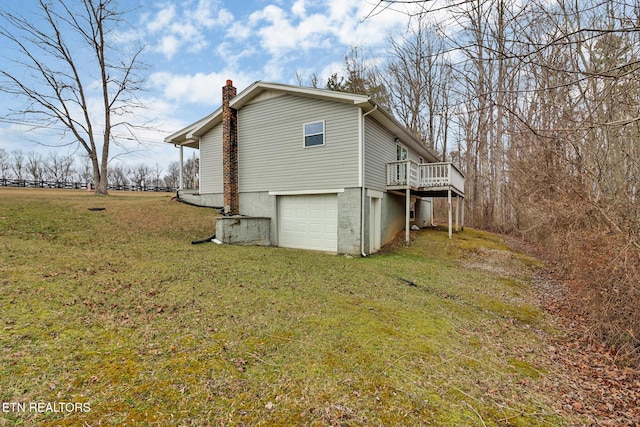 view of property exterior with a garage, a wooden deck, and a yard