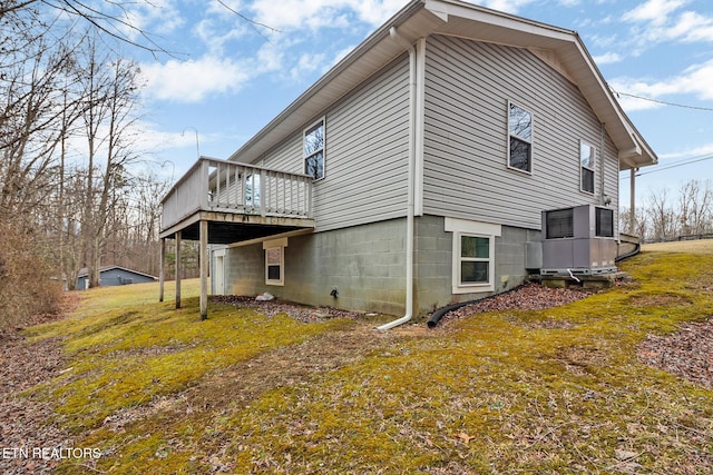 view of home's exterior with a wooden deck and a lawn