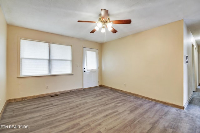empty room featuring ceiling fan and light wood-type flooring