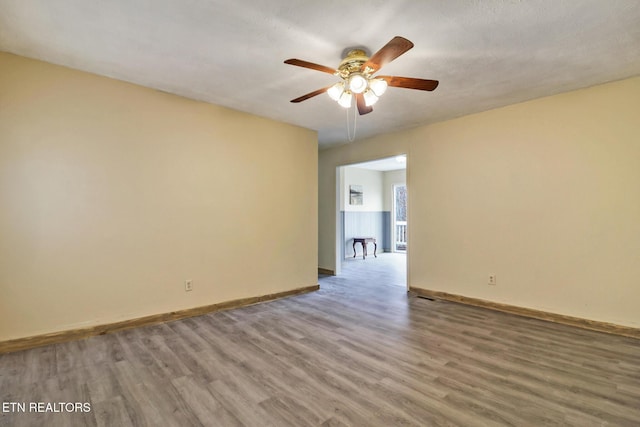 empty room featuring ceiling fan and wood-type flooring
