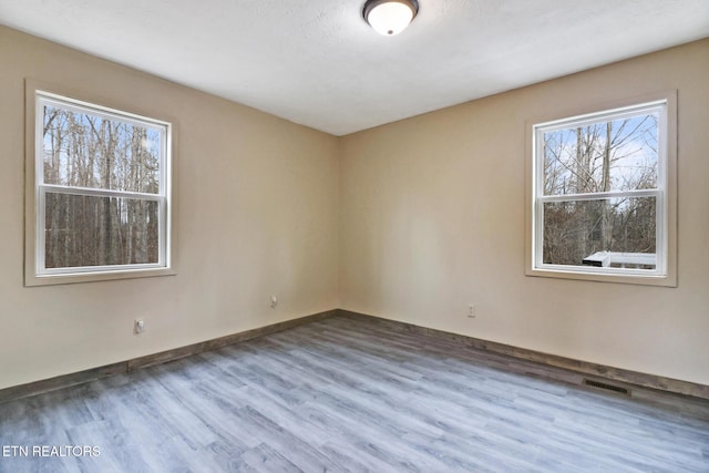 unfurnished room with wood-type flooring