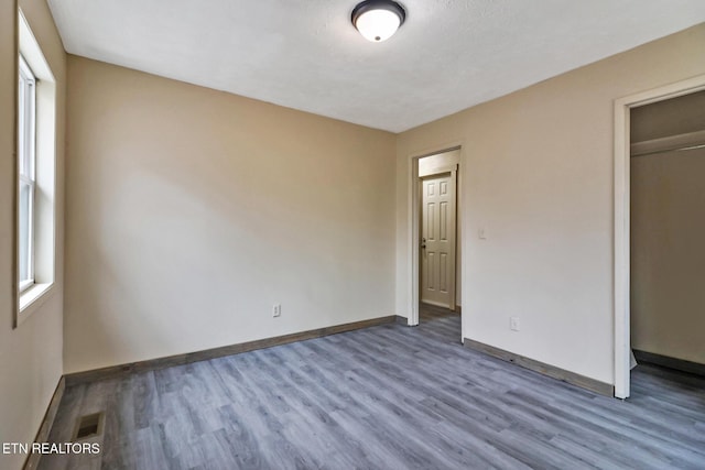 unfurnished bedroom with hardwood / wood-style floors, a textured ceiling, and a closet