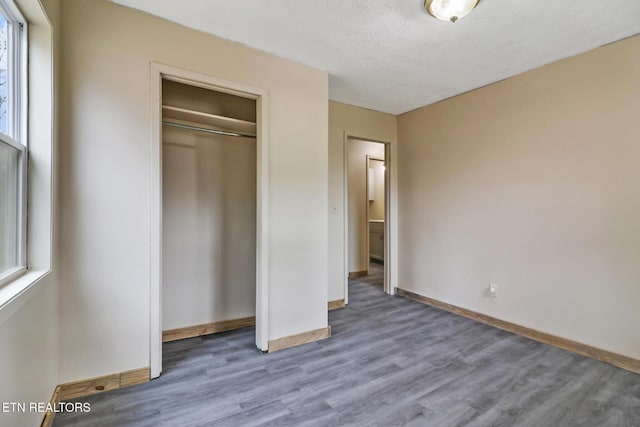 unfurnished bedroom featuring hardwood / wood-style flooring, a closet, and a textured ceiling
