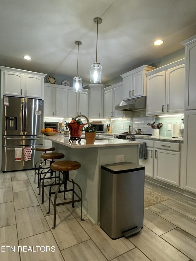 kitchen with white cabinets, hanging light fixtures, and appliances with stainless steel finishes