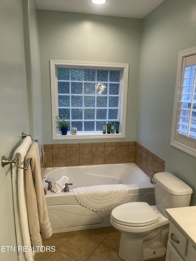 bathroom with tile patterned floors, a washtub, and vanity