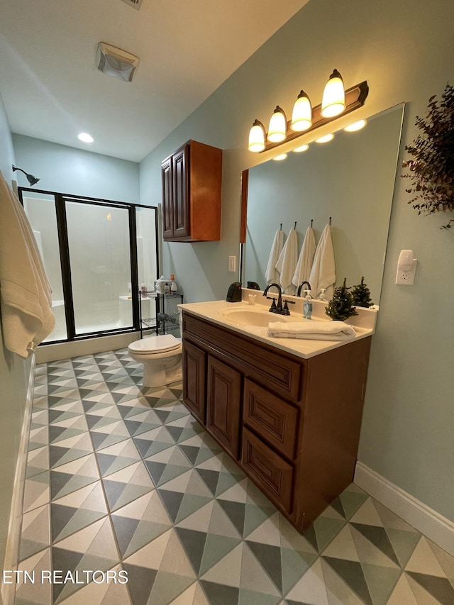 bathroom featuring toilet, a shower with shower door, and vanity