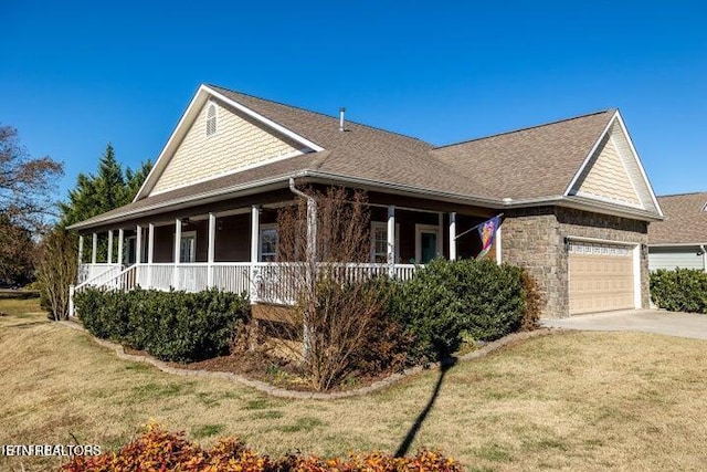 view of front of property with a garage, a front yard, and a porch