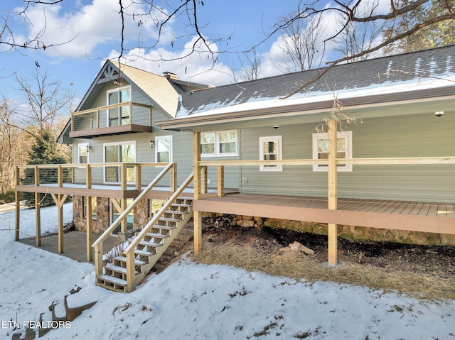 snow covered property with a wooden deck