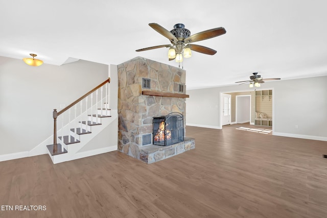 unfurnished living room with ceiling fan, dark wood-type flooring, and a fireplace