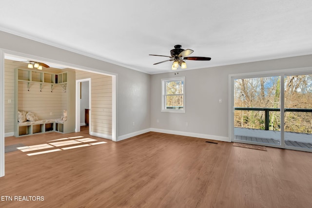 empty room with hardwood / wood-style flooring, crown molding, and ceiling fan