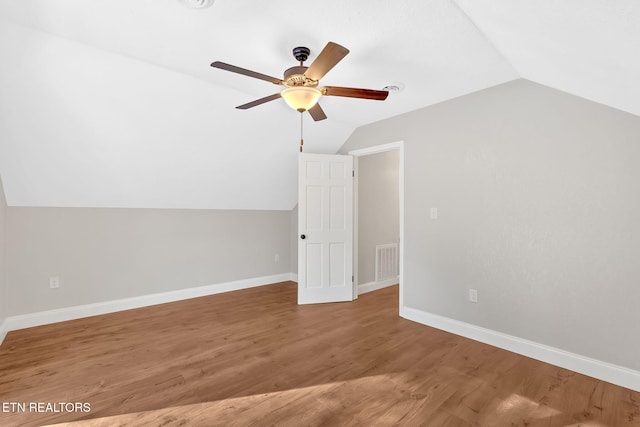 additional living space featuring ceiling fan, vaulted ceiling, and wood-type flooring