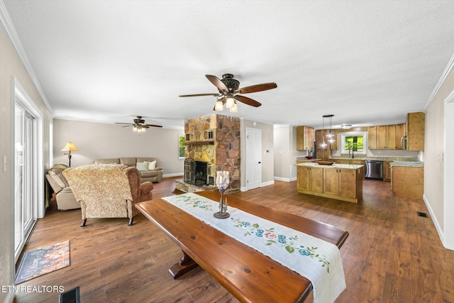living room with ornamental molding, a ceiling fan, and dark wood finished floors