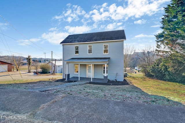 view of front of home featuring covered porch and a front lawn