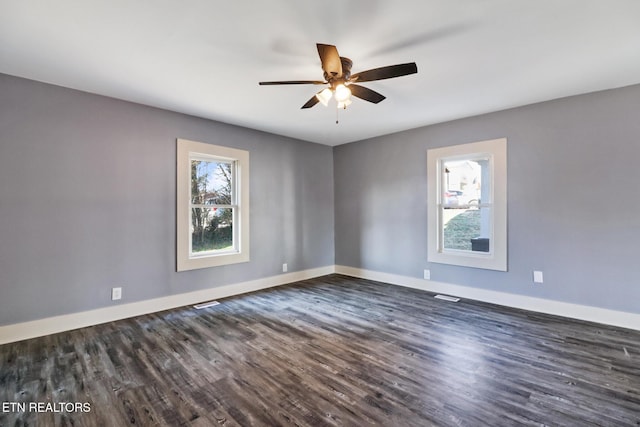 empty room with dark wood-type flooring and ceiling fan