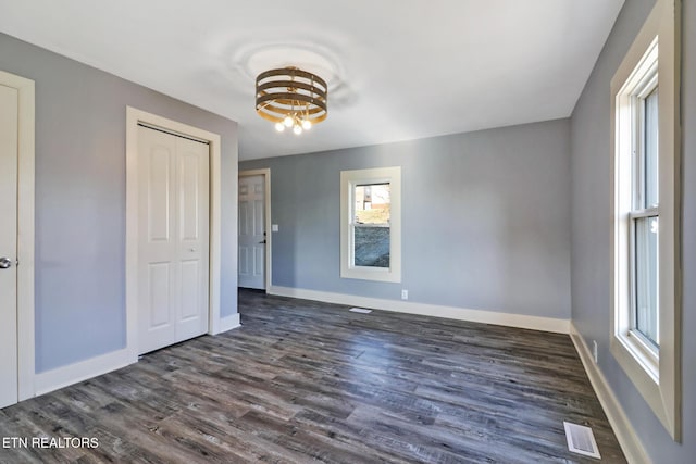 unfurnished bedroom featuring dark wood-type flooring and a closet