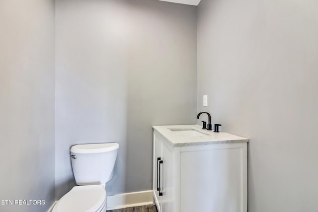 bathroom featuring vanity, wood-type flooring, and toilet