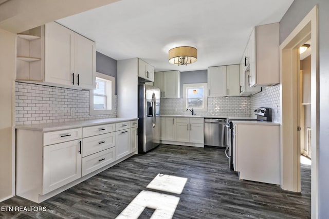 kitchen with white cabinetry, backsplash, dark hardwood / wood-style floors, and appliances with stainless steel finishes