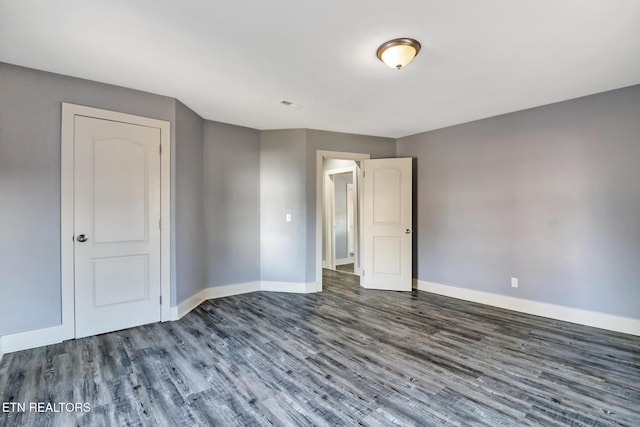 unfurnished bedroom featuring dark hardwood / wood-style floors