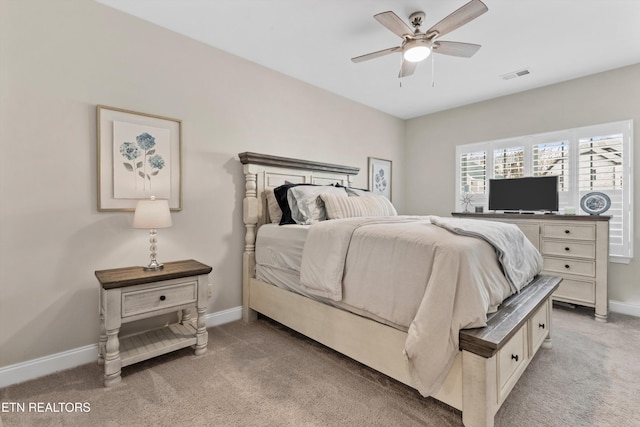 carpeted bedroom with a ceiling fan, visible vents, and baseboards