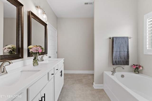 full bath with a sink, visible vents, baseboards, tile patterned floors, and double vanity