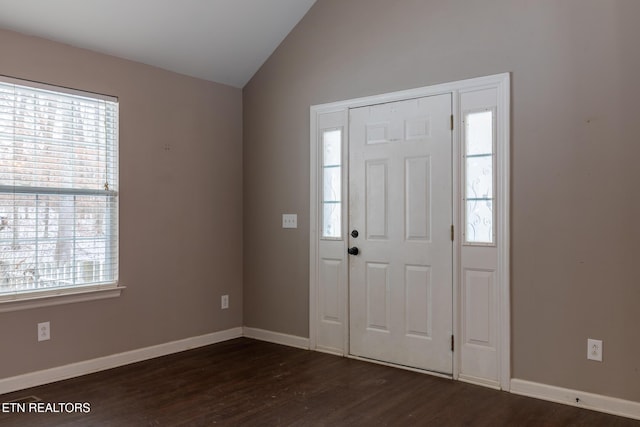 entrance foyer with dark wood-type flooring, a healthy amount of sunlight, and vaulted ceiling